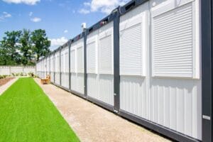 Exterior view of modern container homes with metal siding and adjacent landscaped yard. Casas de Contêiner.