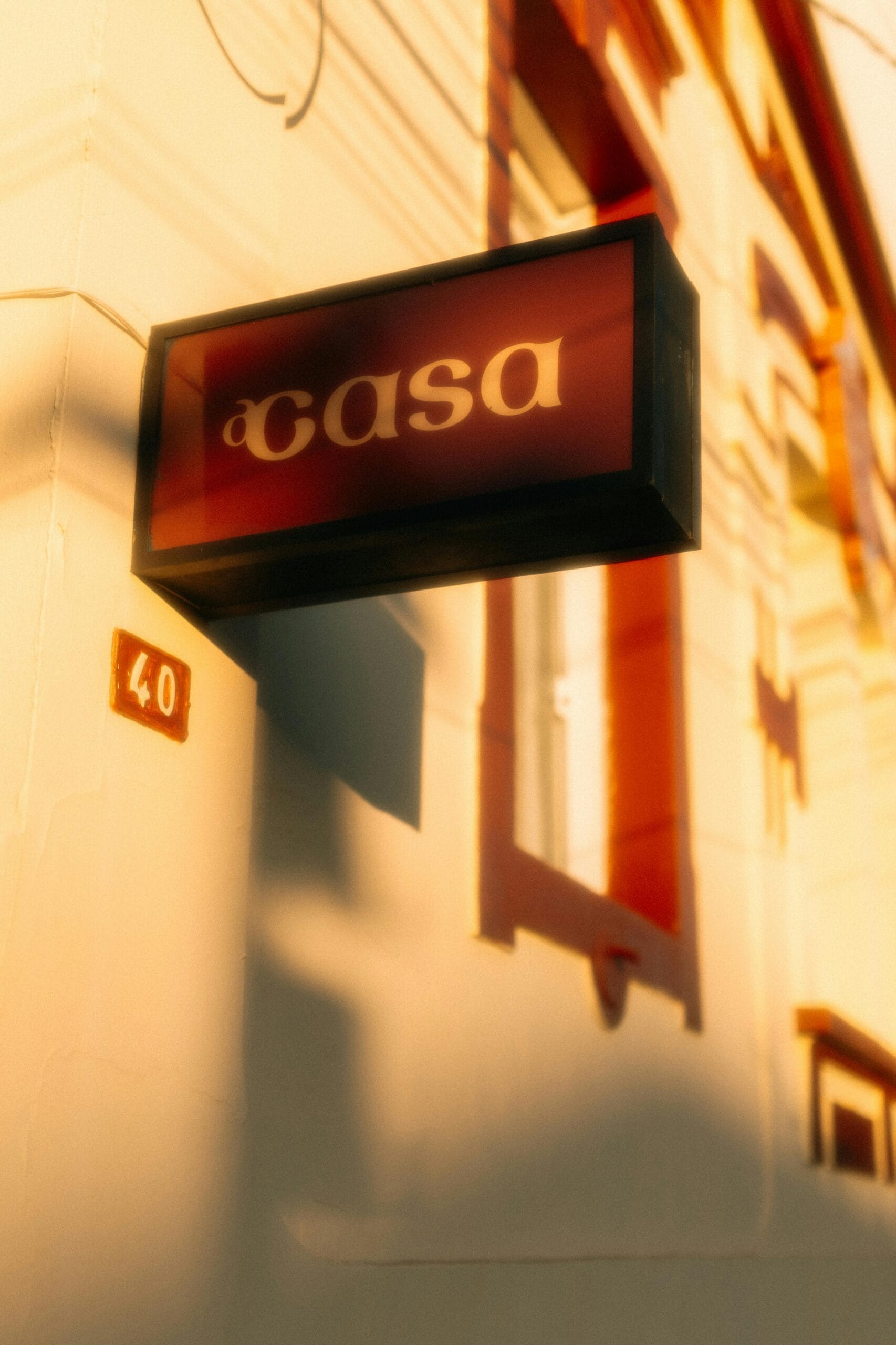 A sunlit urban building featuring a prominent 'Casa' sign and number 40.