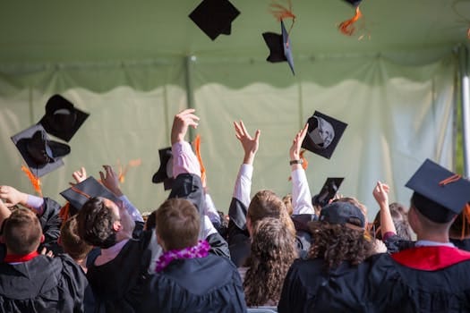 Group of graduates celebrating by tossing caps into the air during a graduation ceremony. Education, Educação.