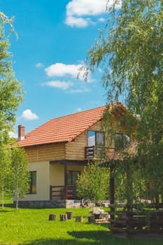 Discover a picturesque rustic house surrounded by vibrant greenery in a serene summer landscape. Jardim Vertical.