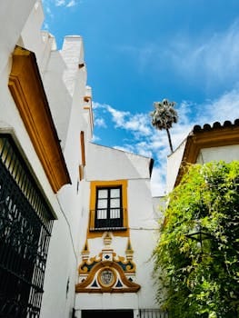 Beautiful Andalusian style courtyard with vibrant colors and unique architectural details under a clear blue sky.Casa Verde Amarela. 