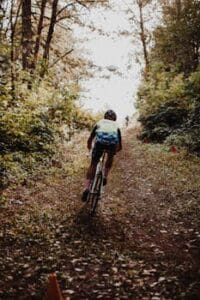 Cyclist mountain biking through a lush forest trail during daytime, Cycling, Ciclismo.