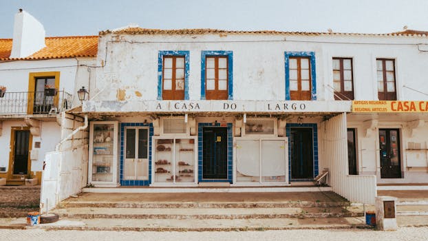 Rustic building facade with blue accents in Nazaré, Portugal, captured on a sunny day.Casa Verde e Amarela.