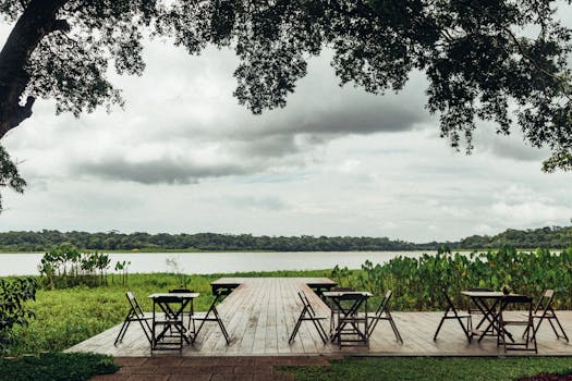 Peaceful riverside setting with chairs on a wooden deck in Nazaré, Brazil. Casas para Alugar.
