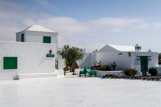 Charming white buildings with green accents under a blue sky in Lanzarote, Spain. casa.