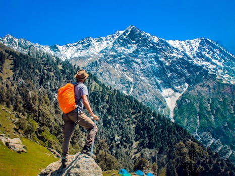 Man exploring breathtaking mountain scenery with snow-capped peaks under a clear blue sky. Trip, Viagem.