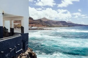 Breathtaking coastal view of Gran Canaria with waves hitting the shore under a sunny sky. Casa, Home.