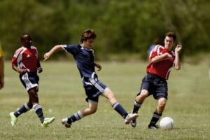 Teenage soccer players in action during an outdoor match showcasing skill and competition. Soccer, Futebol.