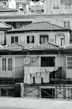 Black and white photo capturing the traditional architecture of Porto, Portugal with hanging laundry. Casa.