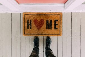 A creative doormat with heart motif symbolizing home at a front porch entrance. Home, Casa.