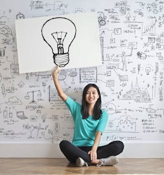 Young woman holds a light bulb drawing against a creative brainstorming wall. Education, Educação.