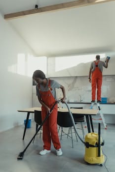 Two cleaners working in a modern kitchen using professional equipment for thorough sanitation. Jobs, Empregos.