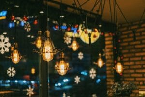 Warm and festive cafe ambiance with hanging bulbs and snowflake decorations. Decoration. Decoração. 