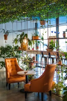 Inviting café corner with lush plants and cozy seating, perfect for relaxation. Jardim Vertical.