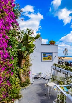 Charming Mediterranean balcony adorned with vibrant bougainvillea, overlooking sea. Jardim Vertical
