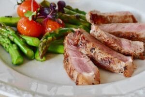 Close-up of grilled steak slices with asparagus and cherry tomatoes, perfect for a healthy meal. Meat, Carne.
