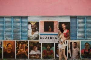 Woman admires vibrant portraits on an urban Brazilian wall. Kitchen, Cozinha.