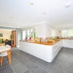 A spacious modern kitchen with elegant interiors featuring a dining table and luxurious design. Kitchen, cozinha.