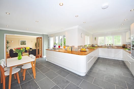 A spacious modern kitchen with elegant interiors featuring a dining table and luxurious design. Kitchen, cozinha.