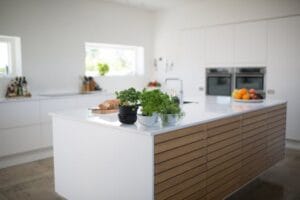 Spacious, light-filled kitchen with modern design and fresh herbs on the counter. Kitchen, cozinha, comida, food.