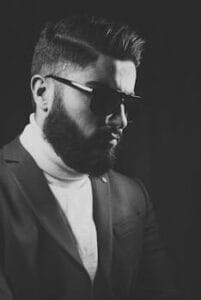 Black and white portrait of a stylish bearded man wearing a suit and sunglasses. Beard, cabelo, vida, saúde, corpo. barba.