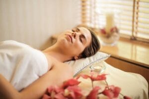 Woman enjoying a relaxing spa day with flowers and candles indoors. Massage, Massagem, nuru.