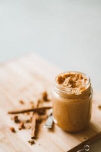 Delicious homemade organic peanut butter in a glass jar on a wooden board. peanut food, Comida, Comida amendoim, peanut food.