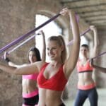 Women exercising with resistance bands in a well-lit rustic studio, promoting fitness and health. Saúde, comida. food.