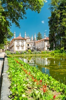 Scenic view of Mateus Palace in Vila Real, Portugal, surrounded by lush gardens and reflecting pond.